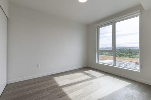 A room with a large window overlooking a parking lot.