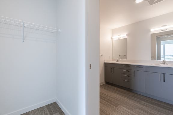 A white bathroom with a vanity and a mirror.