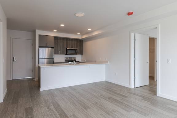 A kitchen with a white countertop and a refrigerator.