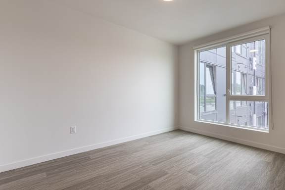 Empty room with a window overlooking a cityscape.