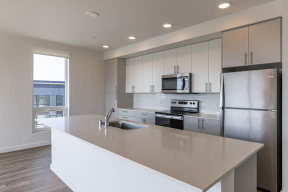 A modern kitchen with a large island and stainless steel appliances.