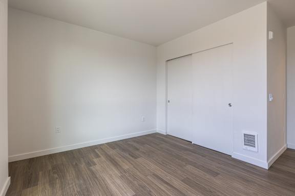 A room with a sliding door and wood flooring.