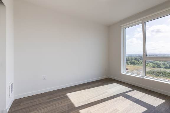 A room with a large window overlooking a landscape.