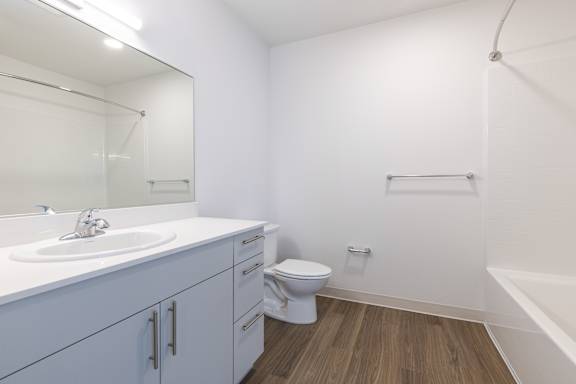 A white bathroom with a toilet, sink, and a bathtub.