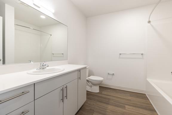 A white bathroom with a sink, toilet, and bathtub.