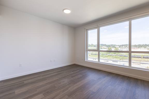 A room with a large window overlooking a parking lot.