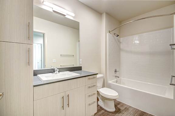 A bathroom with a sink, toilet, and bathtub.
