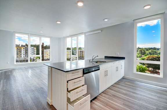 A modern kitchen with a large island and a view of the city.
