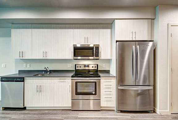 A modern kitchen with stainless steel appliances and white cabinets.