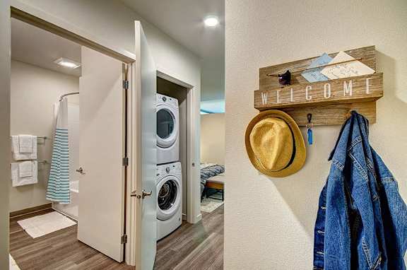 A laundry room with a washer and dryer and a coat rack with a hat and jacket hanging on it.