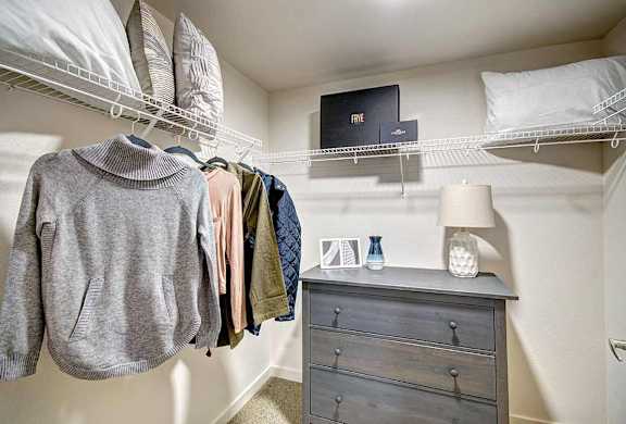 A grey hoodie hanging on a clothes rack in a room.