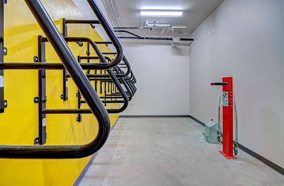 A staircase with a yellow handrail and black metal bars.