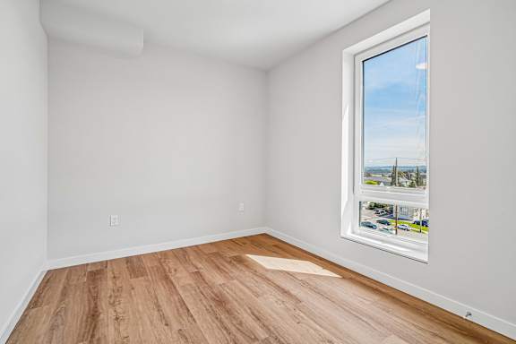 A room with a window showing a view of a bridge and buildings.