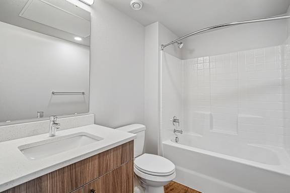 A white bathroom with a toilet, sink, and bathtub.