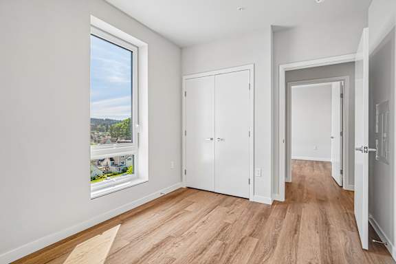 A room with a large window and wooden floors.