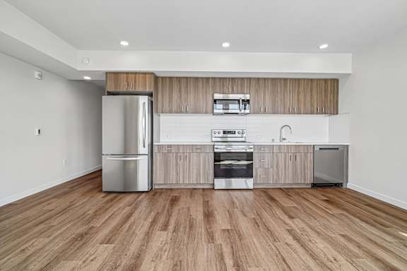 A modern kitchen with wooden cabinets and stainless steel appliances.