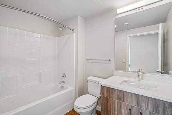 A white bathroom with a toilet, sink, and bathtub.