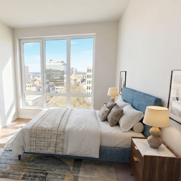 A bedroom with a large bed and a view of the city.