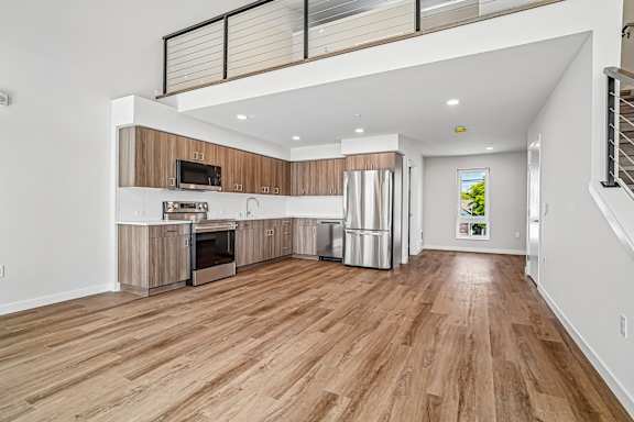 A spacious kitchen with wooden floors and white walls.