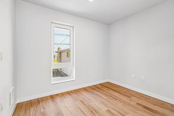 A room with a window showing a view of a building outside.