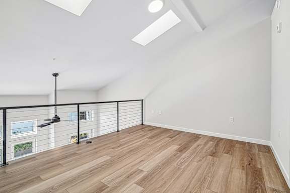 A room with wooden flooring and a black metal railing.
