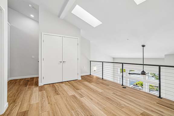A room with a balcony and a skylight.
