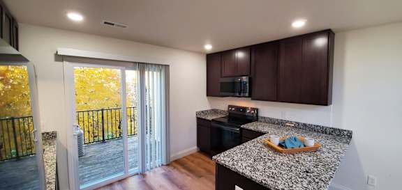 A kitchen with a black stove top oven and a black dishwasher.