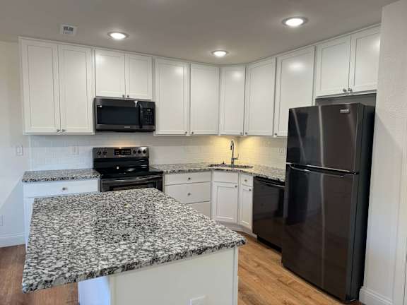A kitchen with granite countertops and stainless steel appliances.