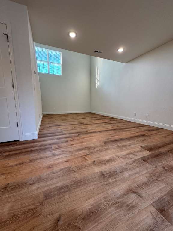 A room with wooden flooring and a window.