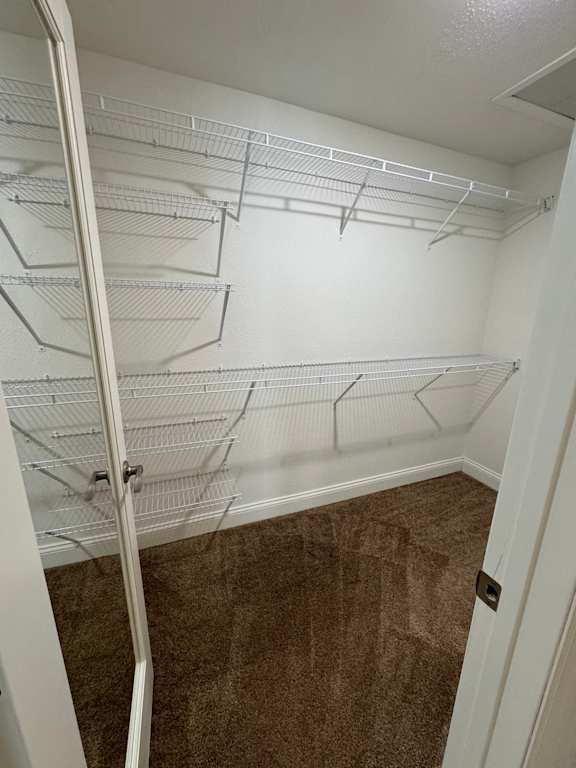 Empty walk-in closet with white shelving.