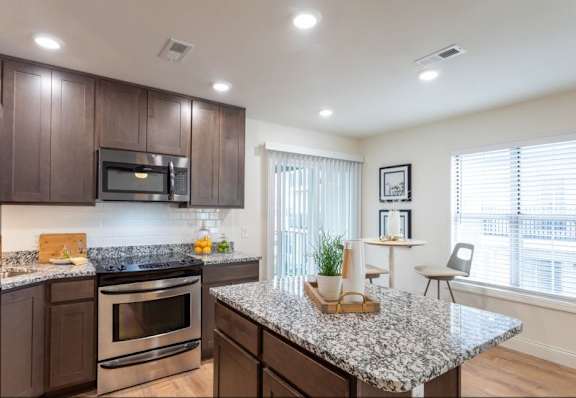 A kitchen with granite countertops and stainless steel appliances.