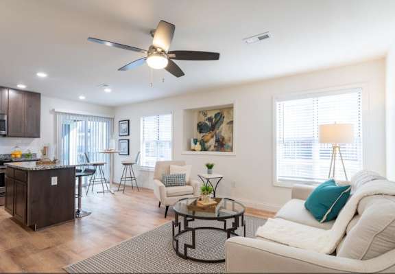 A living room with a white couch and a ceiling fan.