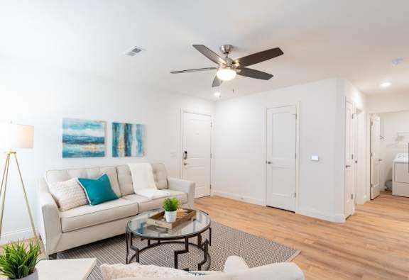 A living room with a white couch and a coffee table.
