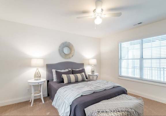 A bedroom with a large bed and a ceiling fan.