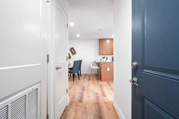 A hallway with a blue door and a white door.