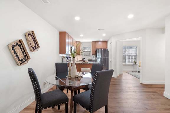 A dining room with a table and chairs.