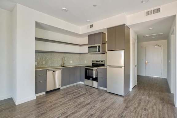 A kitchen with a refrigerator, oven, and microwave.at Catalina West Adams, California