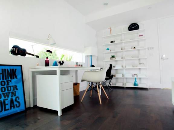 A white desk with a chair and a sign that says "Think of your own ideas".
