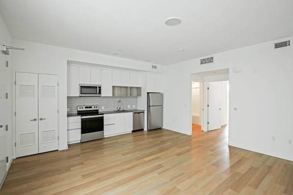 A kitchen with white cabinets and a wooden floor.at The Dillon II at Silver Lake, Los Angeles, CA 90026