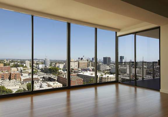 A room with a view of a cityscape through large windows.
