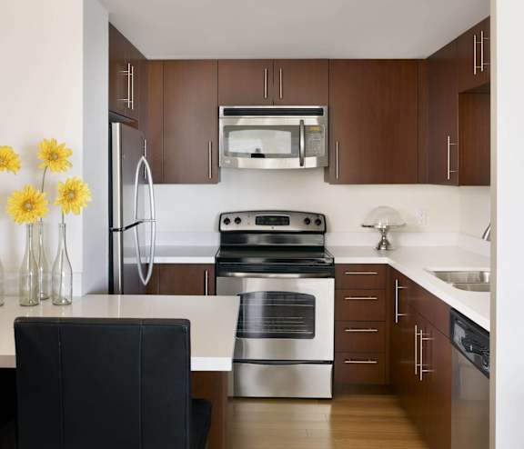 A kitchen with a black chair in the foreground.