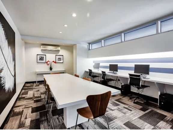 A conference room with a long table and chairs.