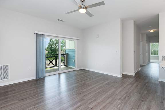 A room with a ceiling fan and sliding glass doors at The Banks at Bridgewater Apartments, South Carolina