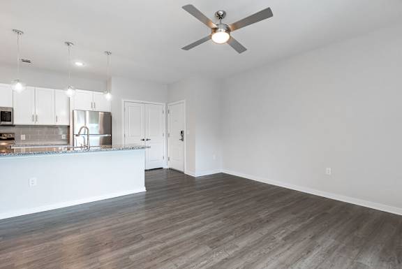 A spacious kitchen and living room with a ceiling fan and hardwood floors at The Banks at Bridgewater Apartments, South Carolina