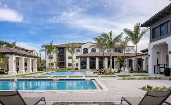 A swimming pool in front of a row of houses at Las Palmas Apartments, Florida
