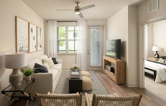 A living room with a sofa, a chair, a coffee table, and a television.