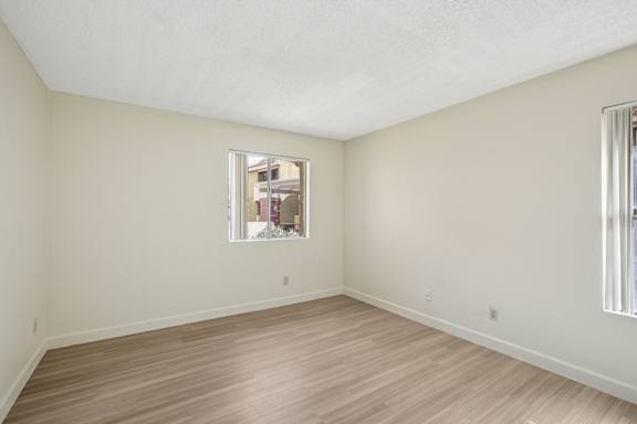 Empty room with wooden floor and a window.