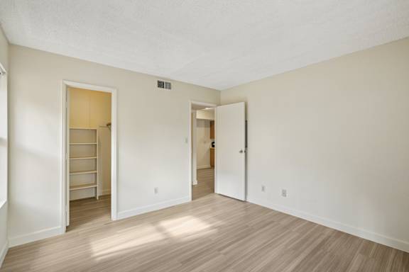 A room with a white door and a wooden floor.