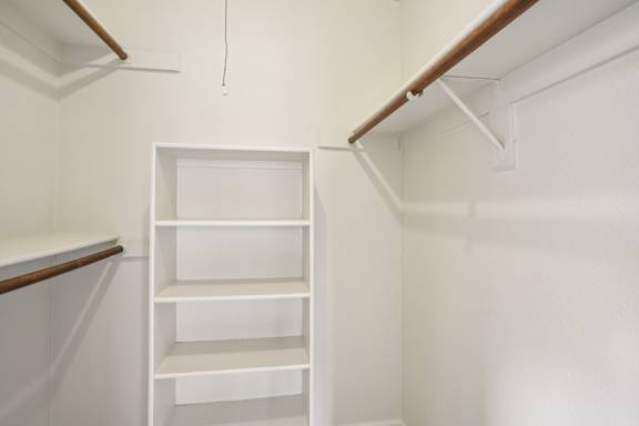 A white shelving unit in a room with white walls.
