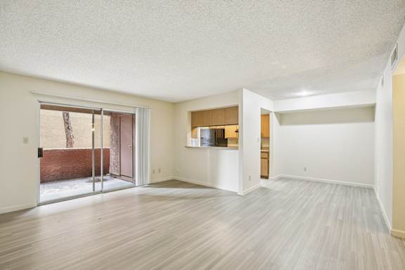 A room with a sliding glass door leading to a balcony.